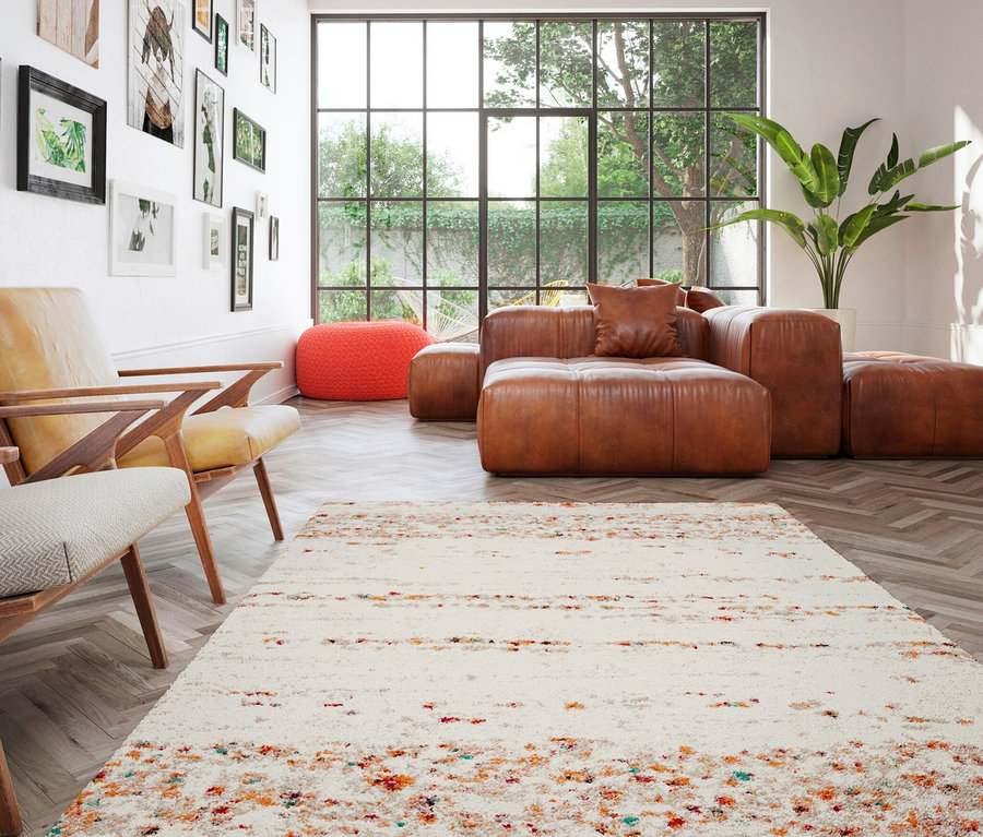 Wohnzimmer mit beigem Teppich »Himalaya«, braunem Ledersofa und Sesseln.