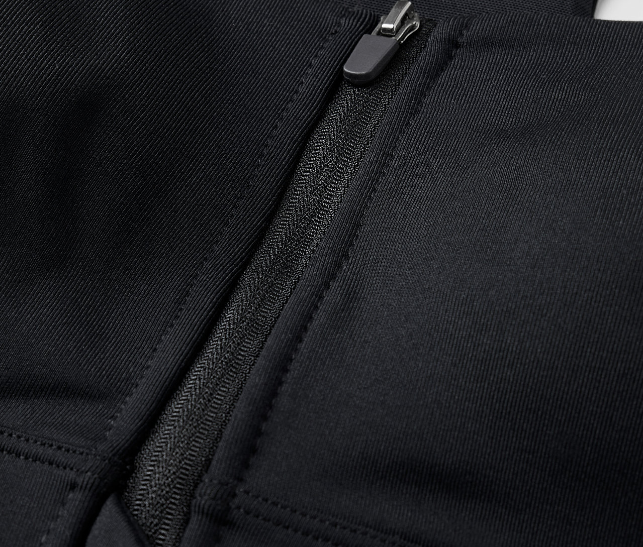 Detailaufnahme eines schwarzen Sport-BHs mit Frontreißverschluss.