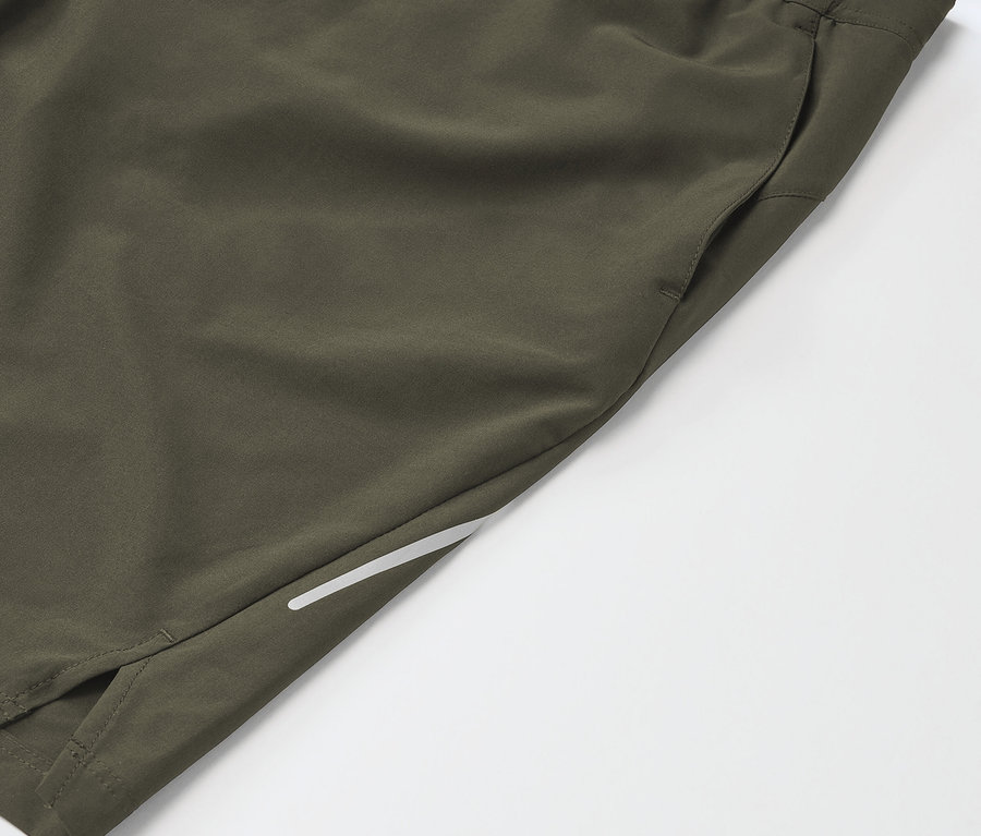 Detailaufnahme von khakifarbenen Sportshorts mit Tasche und reflektierendem Streifen.