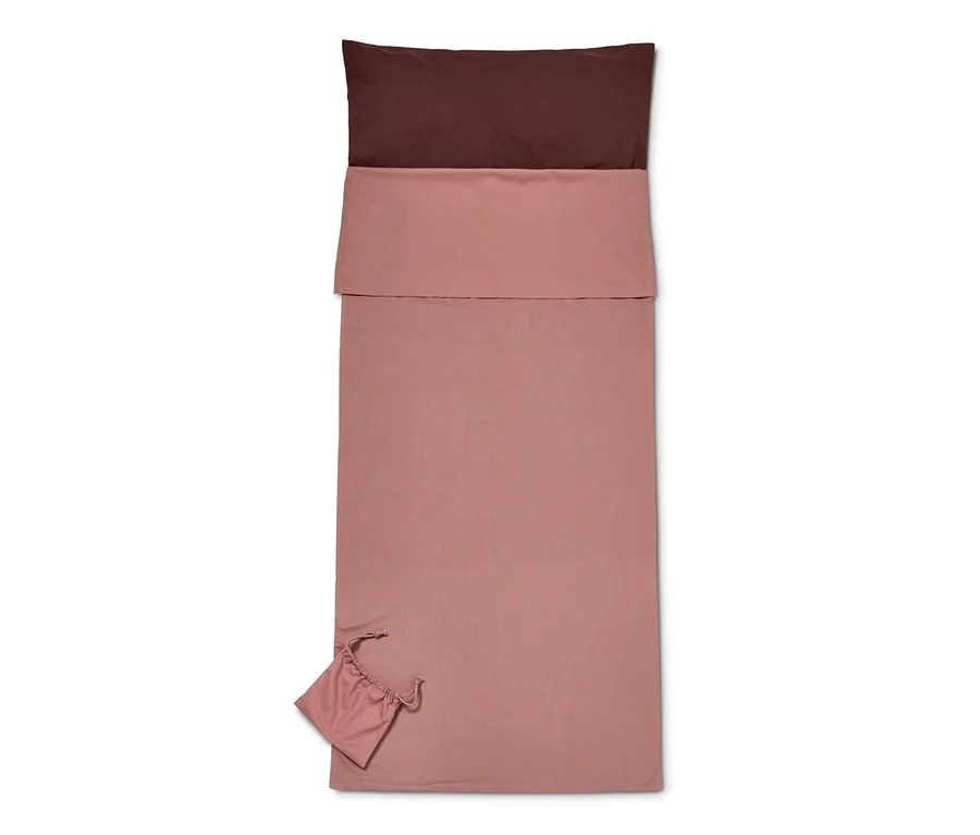 Ein ausgerollter Hüttenschlafsack mit einem braunen Oberteil und dem Rest des Schlafsacks und der Tragetasche in Rosa.