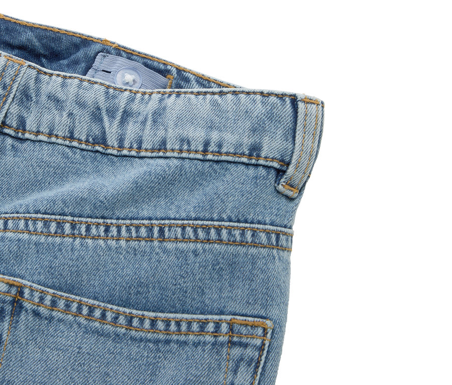 Detail einer blauen Jeans mit verstellbarem Bund und Gürtelschlaufe.