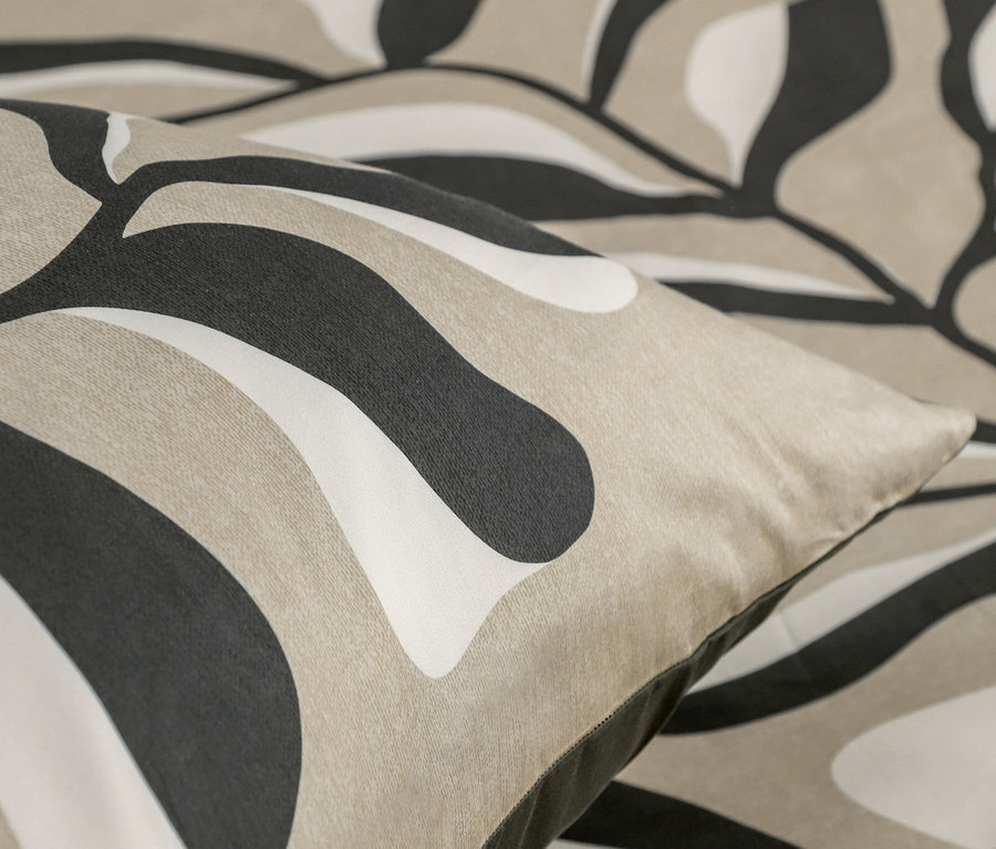 Detail eines Kissens mit abstraktem Muster in Beige, Weiß und Schwarz.