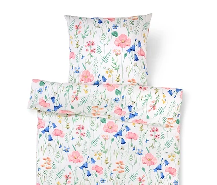 Weiße Bettwäsche mit Blumenmuster zeigt rosa Mohnblumen und blaue Glockenblumen.