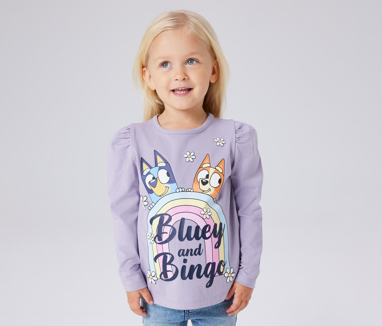 Mädchen trägt ein lila NAME IT Kinder-Langarmshirt »BLUEY« mit Bluey- und Bingo-Print.