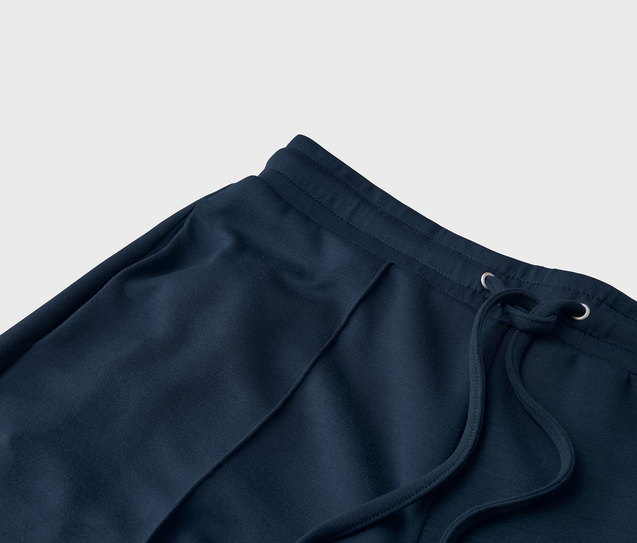 Detailaufnahme einer marineblauen Jogginghose mit Kordelzug.