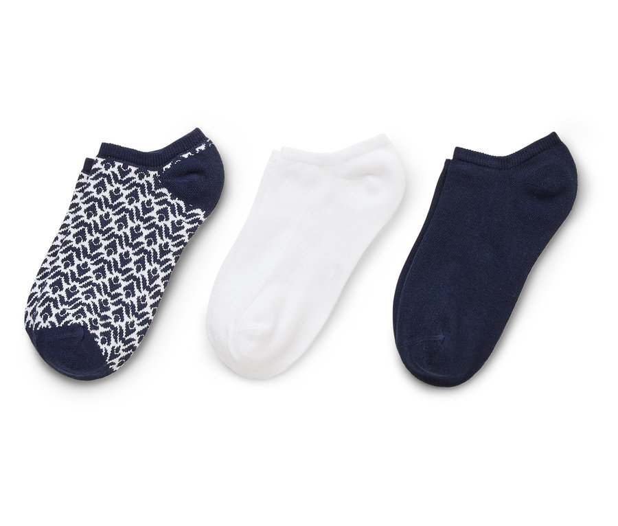 Drei Socken liegen auf einem weißen Hintergrund. Eine Socke ist weiß, eine ist dunkelblau und eine ist dunkelblau mit einem weißen Muster.