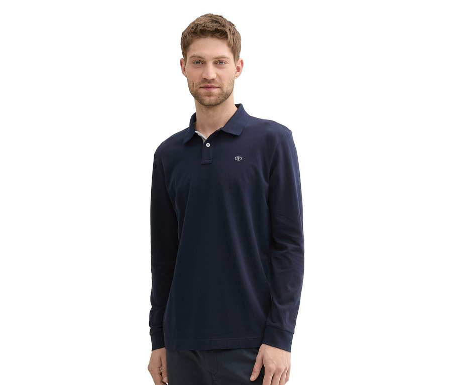 Mann trägt ein Tom Tailor Longsleeve Piqué Poloshirt in Sky Captain Blue.