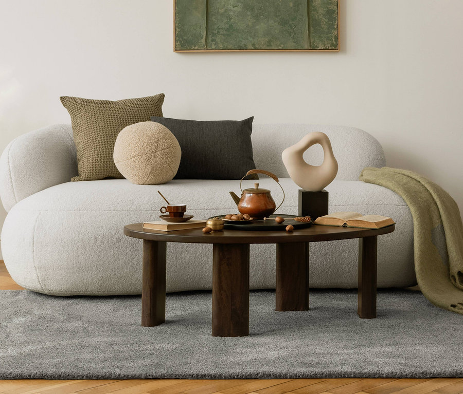 Wohnzimmer mit grauem »Jane« Teppich, Sofa, Kaffeetisch mit Teekanne und Deko.