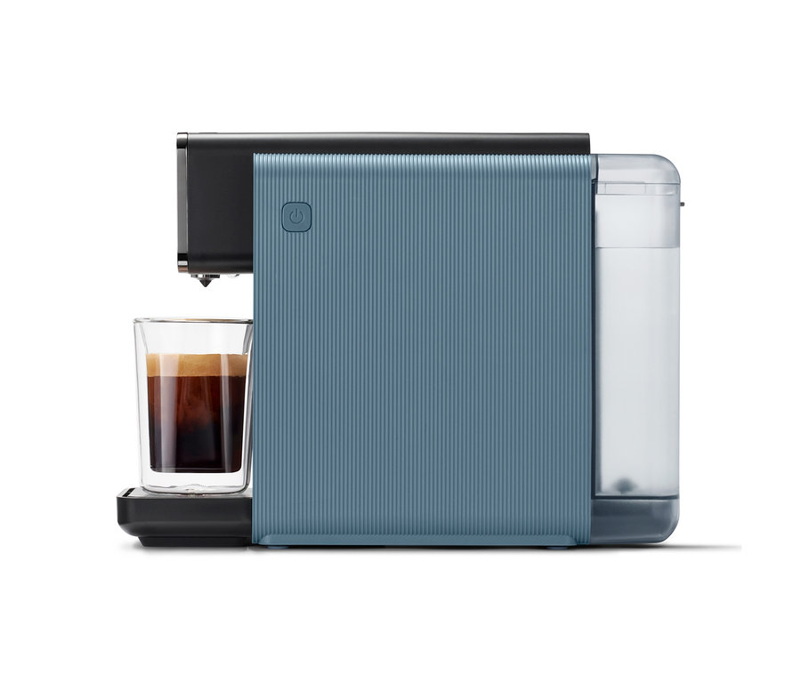 Blaue »Qbo ONE« Kapselmaschine mit gerippter Oberfläche, einem gefüllten Wassertank und einer Tasse Kaffee unter dem Auslauf.