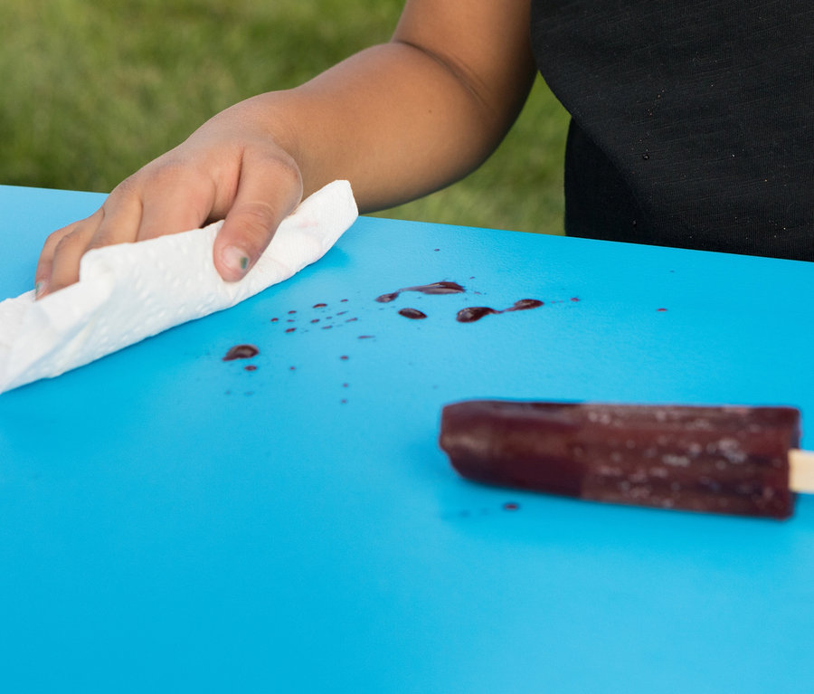 Hand wischt blauen LIFETIME Kinder-Picknicktisch »80094G« von rotem Fleck neben Eis am Stiel.