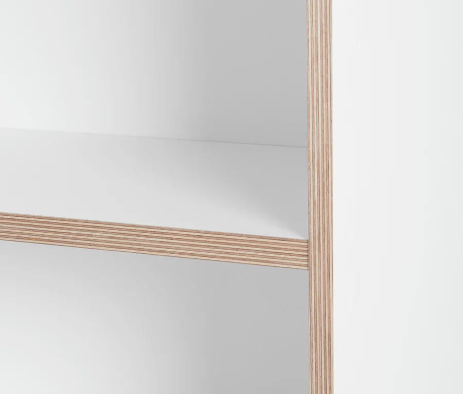 Detailaufnahme eines weißen Regals mit Holzkante.