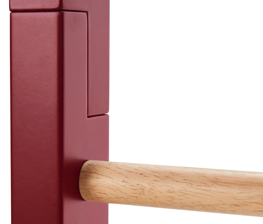 Detail einer Dekoleiter mit roten Seitenelementen und einer Holzstange.