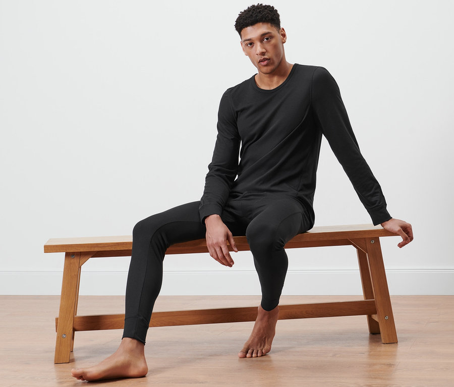 Mann sitzt auf Bank und trägt Thermo-Funktionsunterwäsche.
