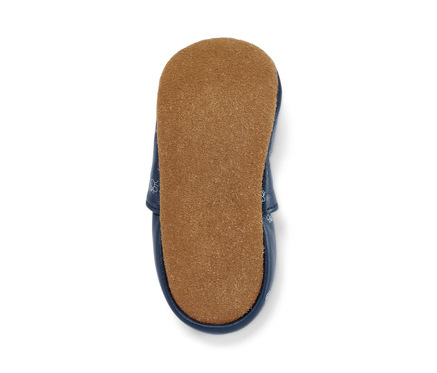 Detailaufnahme eines Baby-Lederschühchens mit brauner Sohle.