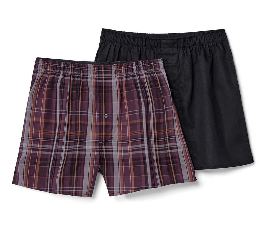 Zwei Webboxershorts, eine kariert, eine schwarz.