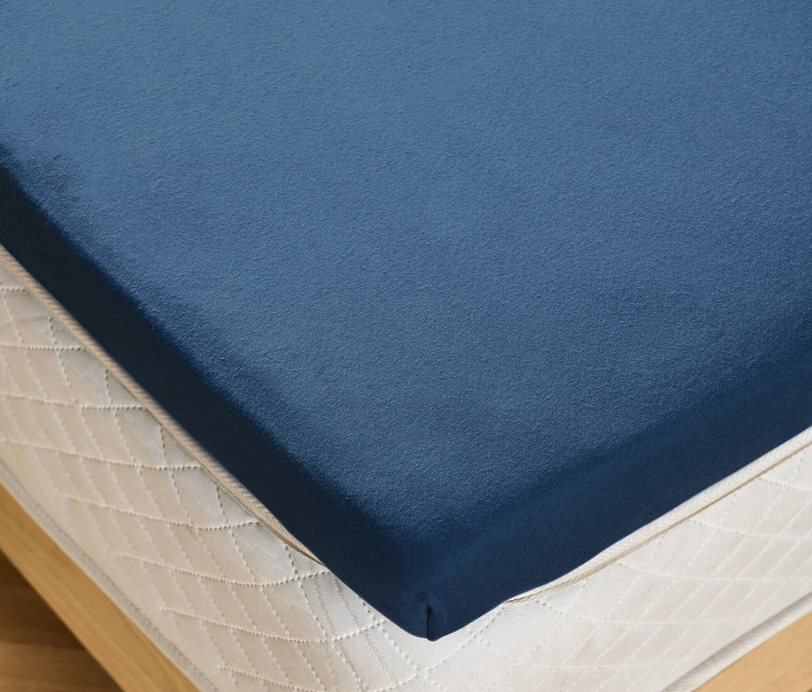 Detailansicht eines blauen Topper-Spannbettlakens auf einer Matratze.