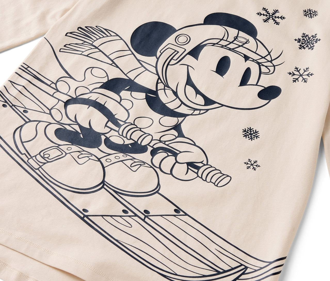 Comicfigur Minnie Maus auf Skiern mit Helm, Schal und Handschuhen auf beigem Hintergrund.