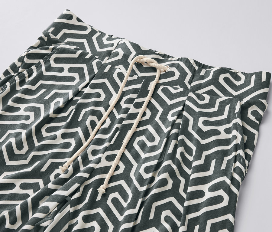 Detailaufnahme einer grün bedruckten Jerseyhose mit Kordelzug.