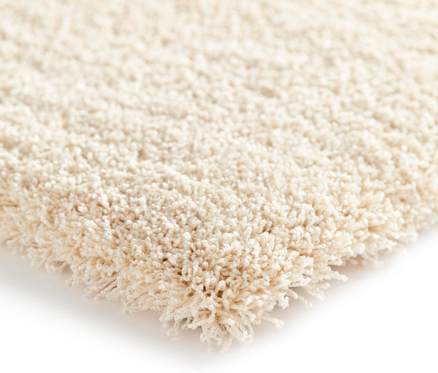 Detailaufnahme einer Ecke des wollweißen Teppichs »Mellow«.