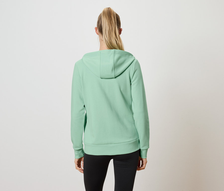 Rückansicht einer Frau mit blonden, zum Pferdeschwanz gebundenen Haaren, die einen hellgrünen Kapuzenpullover und schwarze Leggings trägt.