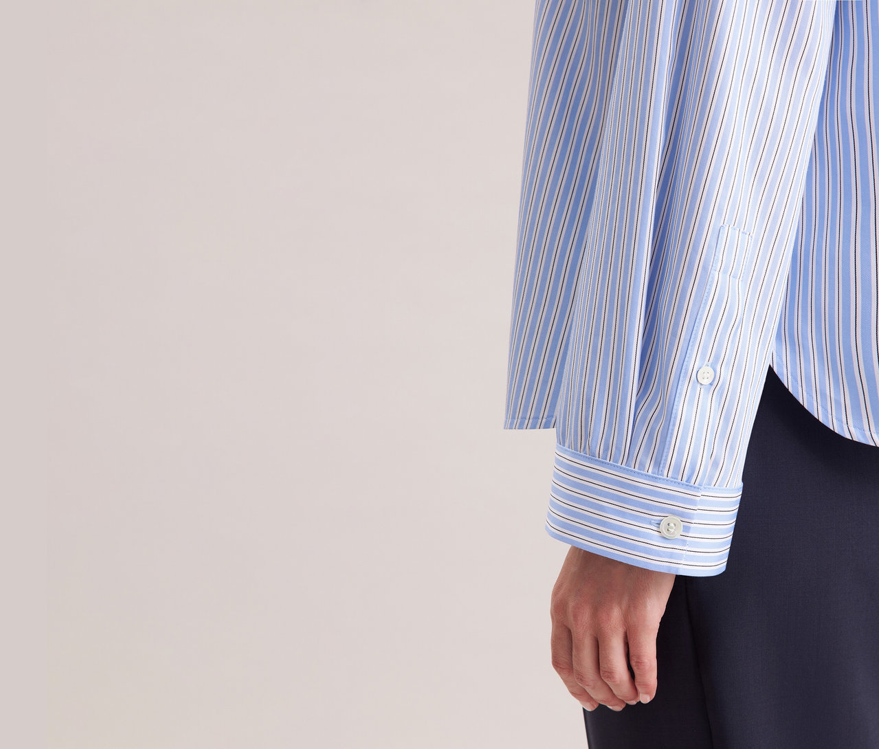 Frau trägt eine blau-weiß gestreifte Seidensticker Oversize-Hemdbluse.