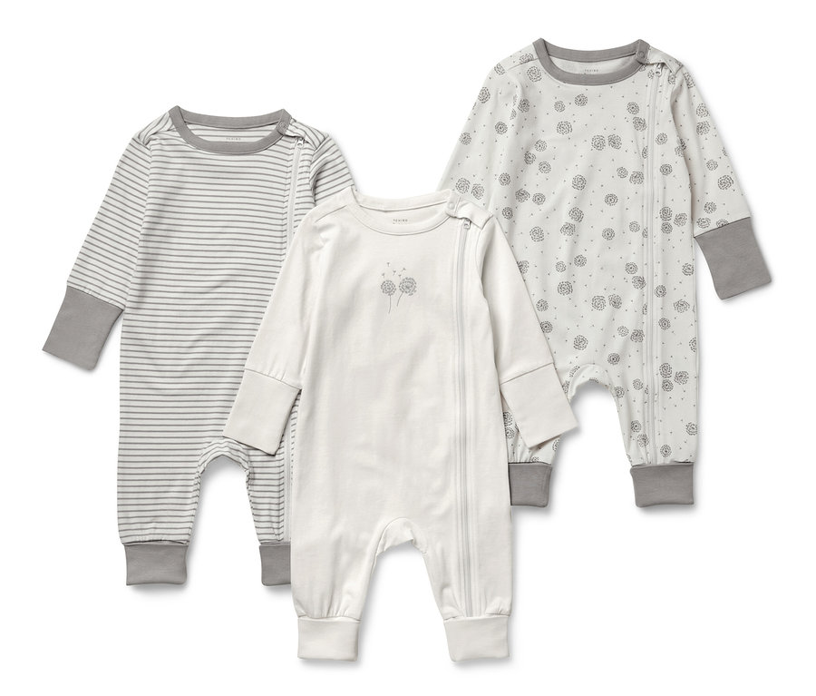 Drei Baby-Schlafanzüge mit langen Ärmeln. Einer gestreift, einer mit Blumendruck und einer weiß.