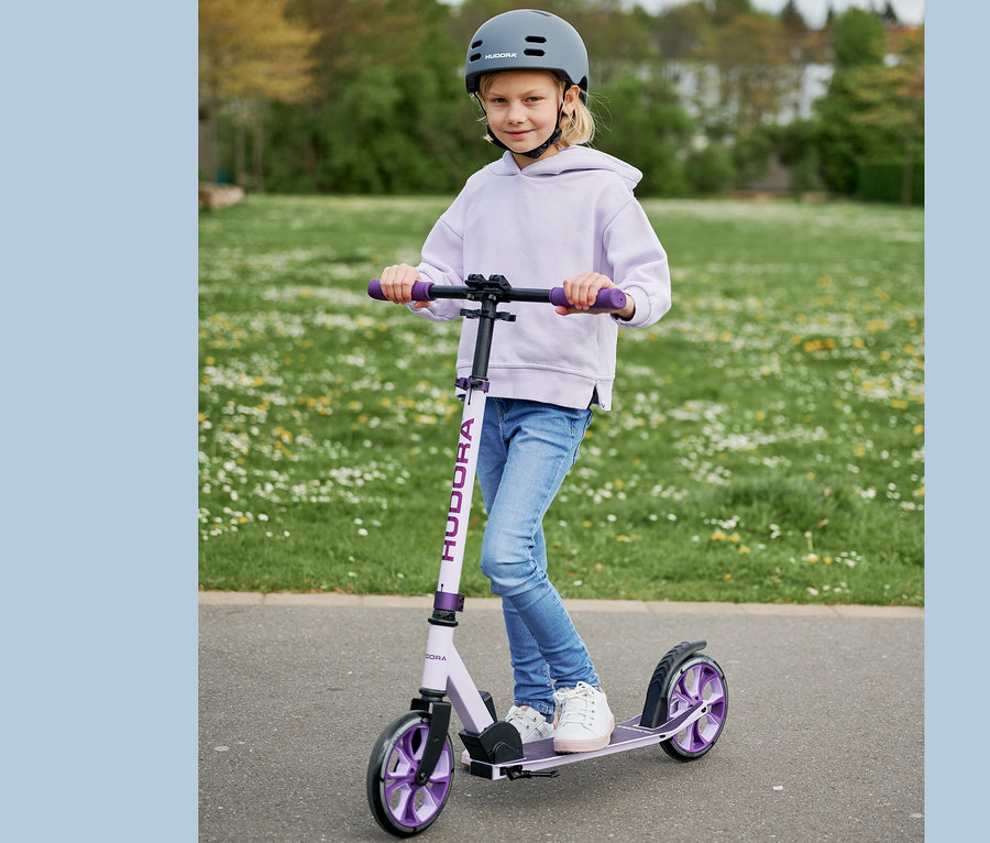 Mädchen fährt mit einem lavendelfarbenen HUDORA BigWheel® 205 advanced Roller in einem Park.