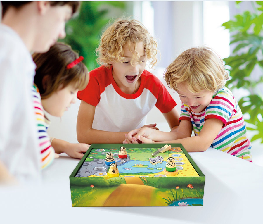 Drei Kinder spielen das Spiel »Beppo« auf einem Tisch.