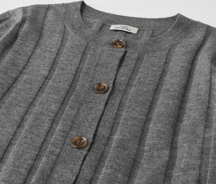 Detailansicht einer grauen Strickjacke mit Knöpfen.