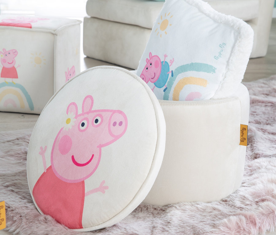 Peppa Pig Motiv auf rundem Kissen neben offenem Hocker und Würfel auf einem Teppich.
