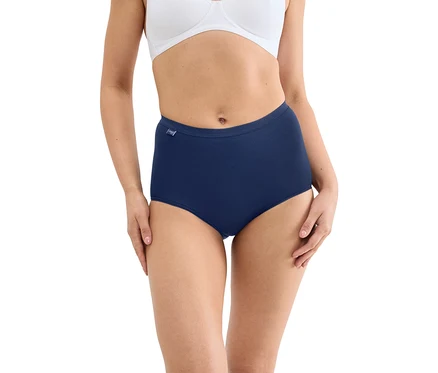 Eine Frau trägt einen weißen BH und einen marineblauen High-Waist-Slip vor einem weißen Hintergrund. Ihre Hände ruhen auf ihren Oberschenkeln.