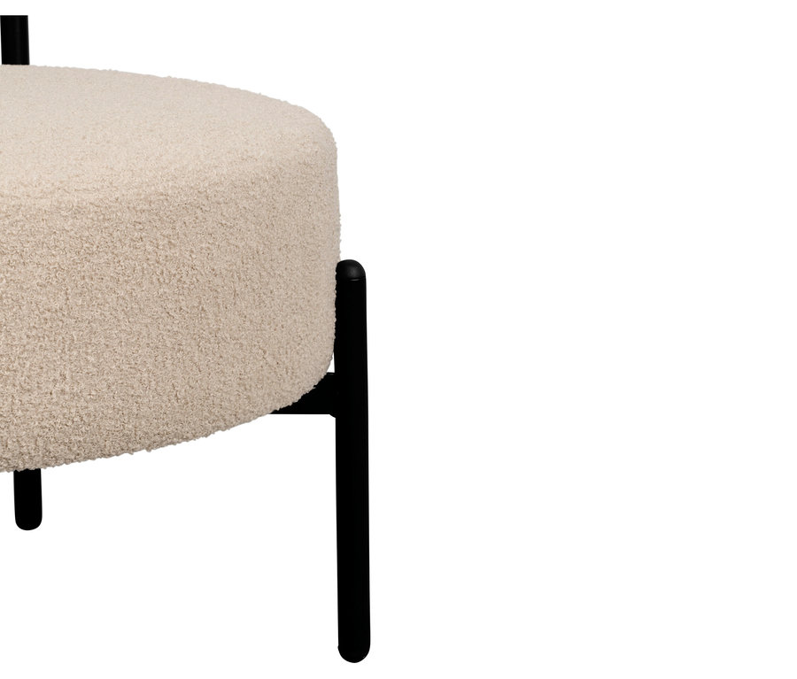 Nahaufnahme eines cremefarbenen Hockers mit schwarzem Metallfuß.