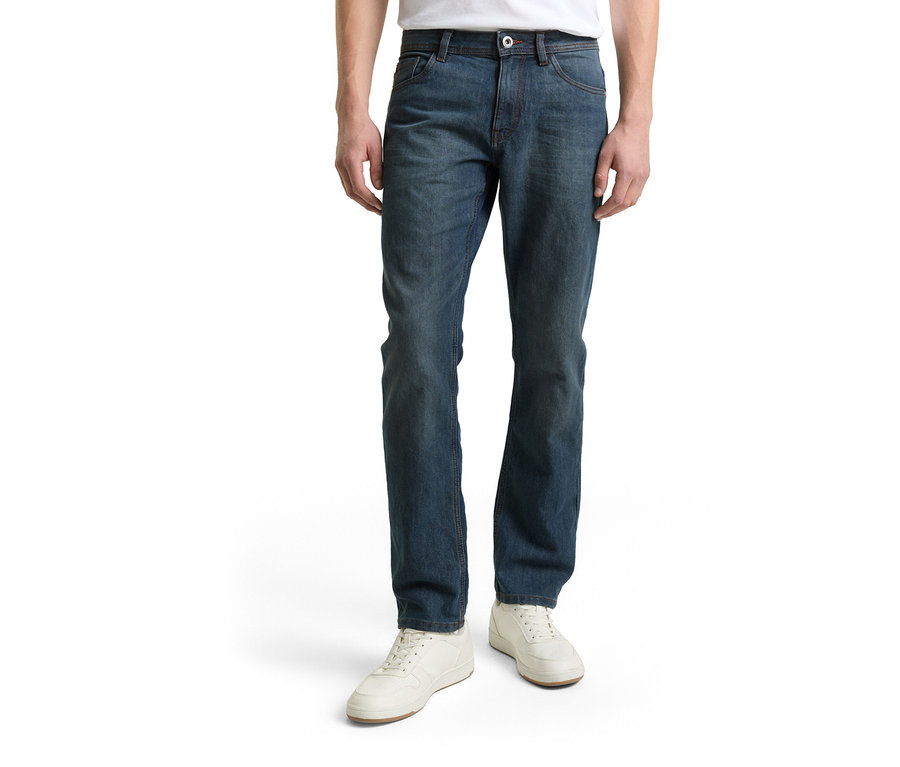 Mann trägt Tom Tailor TT MARVIN STRAIGHT Jeans mit Stretch in Mid Stone Blue Grey Denim und weiße Schuhe.