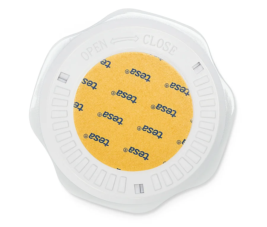 Draufsicht auf eine runde, weiße Tesa Klebefilm-Box mit gelbem Klebefilm, der mit dem Tesa-Logo bedruckt ist.