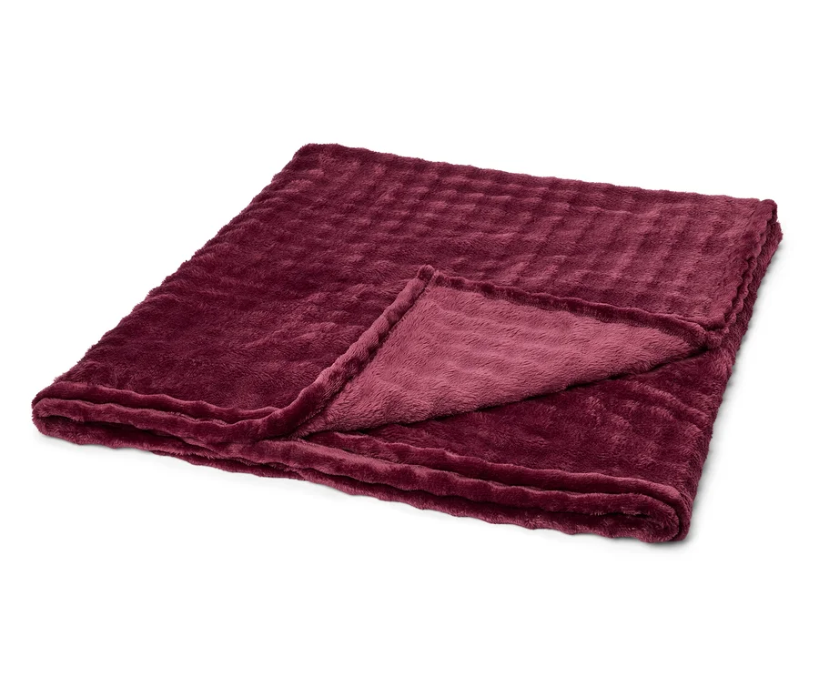 Eine gefaltete, weinrote Kuscheldecke mit gerippter Textur liegt auf einem weißen Hintergrund. Eine Ecke ist umgeschlagen.