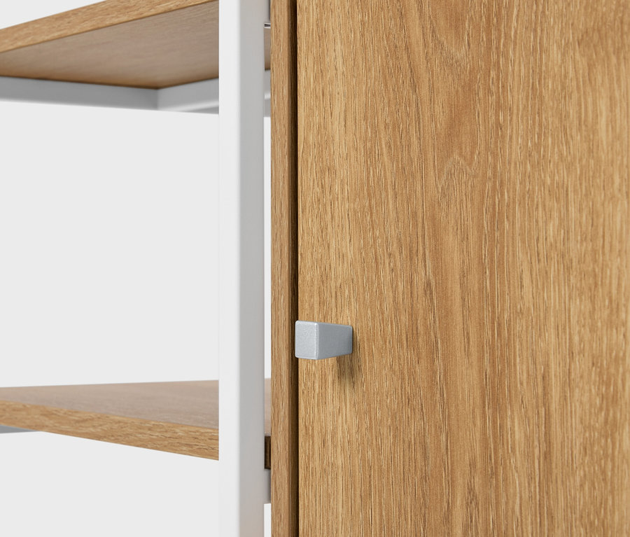 Detailansicht eines Regals mit Holzregalen und einer Holztür mit einem quadratischen silbernen Griff.