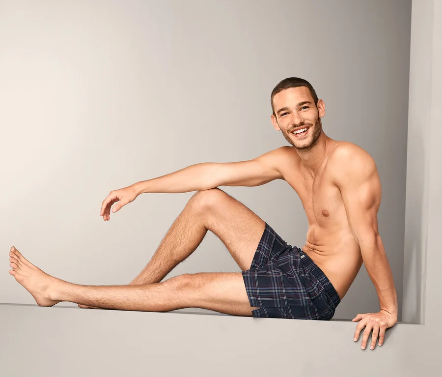 Mann sitzt da und trägt eine der 2 Flanell-Boxershorts.