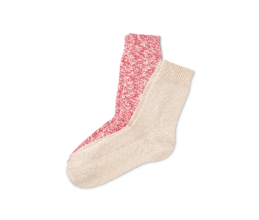 Zwei Paar Stricksocken: ein Paar rot-weiß, ein Paar cremefarben.