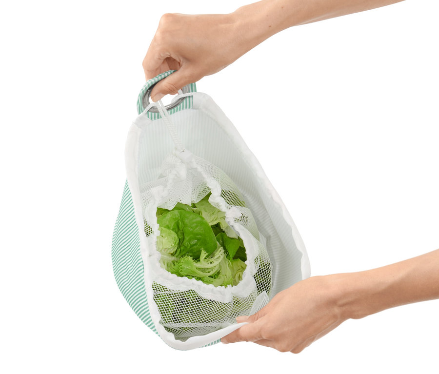 Person hält einen Salatschleuderbeutel mit Kopfsalat darin.