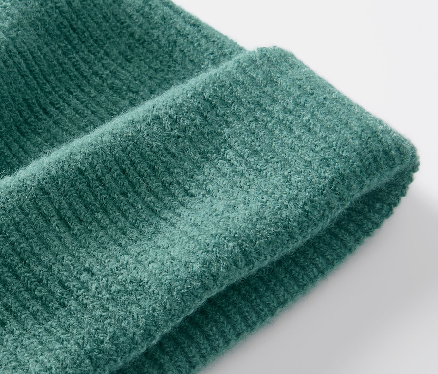 Detailaufnahme einer grünen Strickmütze.