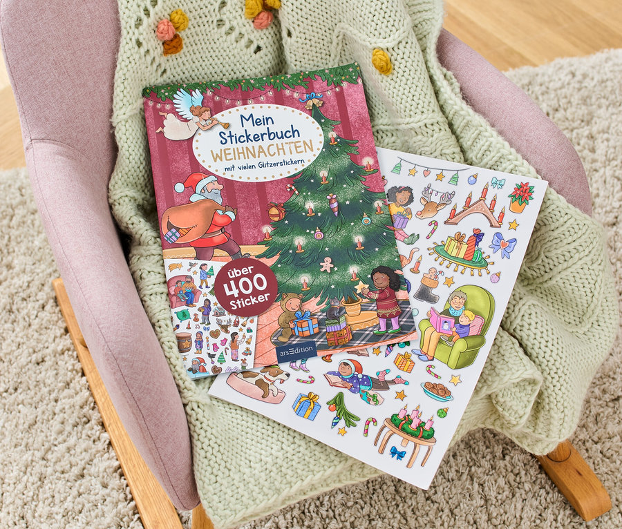 Auf einem Sessel liegt ein geöffnetes Weihnachtsstickerbuch mit Weihnachtsmotiven.