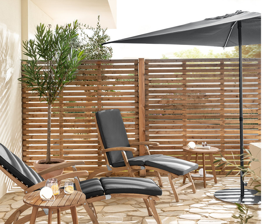 Zwei Deckchairs mit Polsterauflage und zwei Beistelltische mit 2 Ebenen »Lenja« stehen auf einer Terrasse. Auf einem Tisch steht ein Akku-Tischleuchten-Set. Ein flacher Leco Sonnenschirmständer und ein Leco Marktschirm sind auch sichtbar.