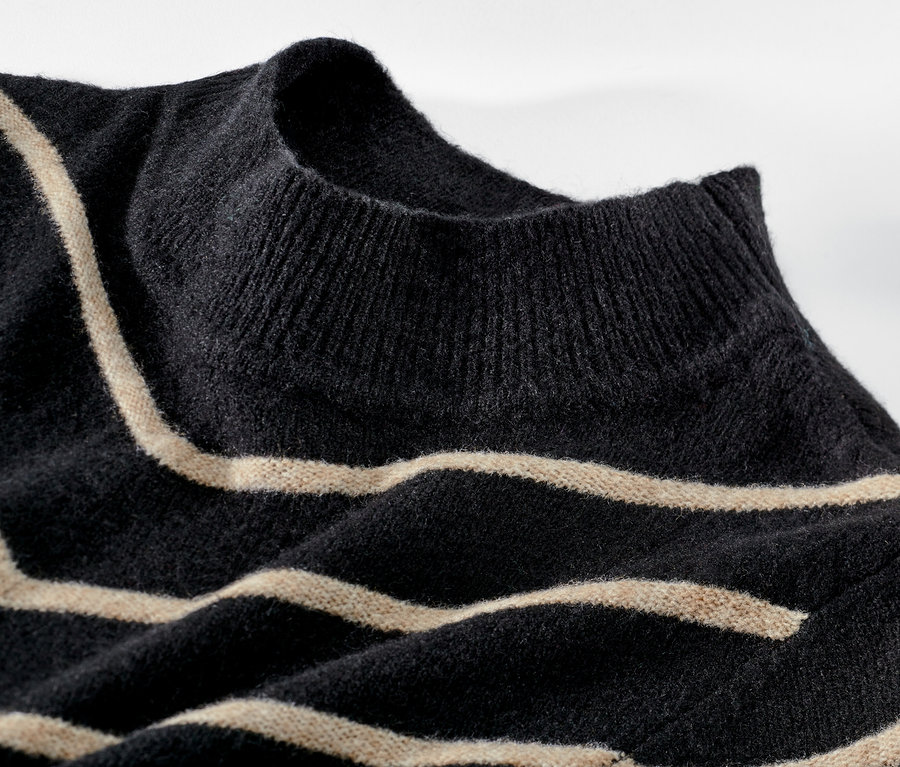 Detailansicht eines schwarz gestreiften Strickpullovers mit Stehkragen.