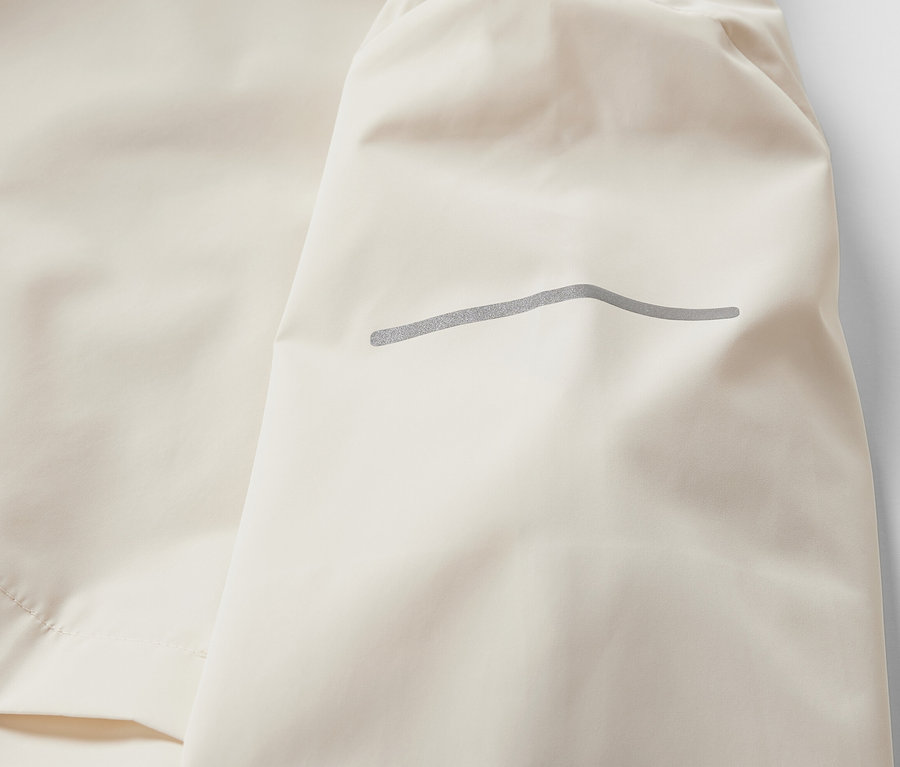 Detailansicht einer creme-farbenen Windprotection-Laufjacke.