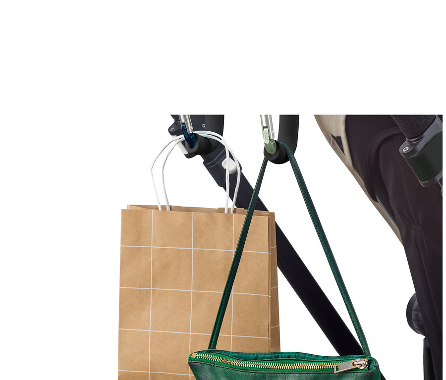 Eine Einkaufstasche und eine grüne Handtasche hängen mit 2 XXL-Karabinerhaken an einem Kinderwagen.