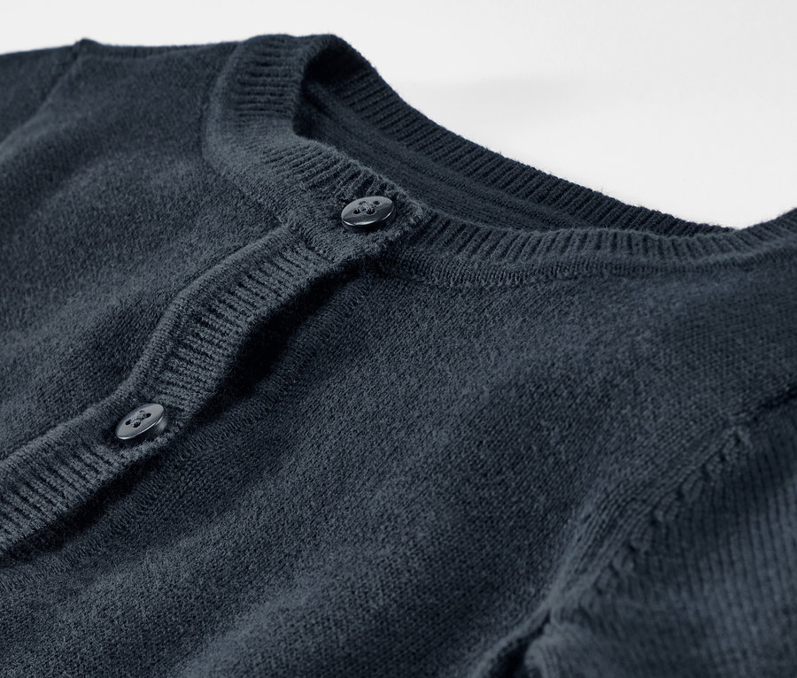 Detailaufnahme einer Kinder-Strickjacke mit Knöpfen.