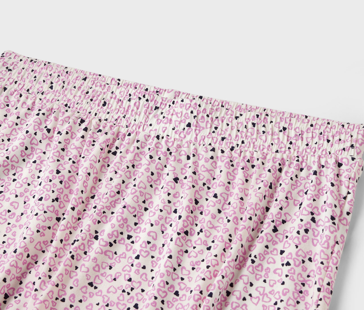 Detail einer Damenhose mit Gummibund und einem Allover-Druck aus kleinen Herzen.