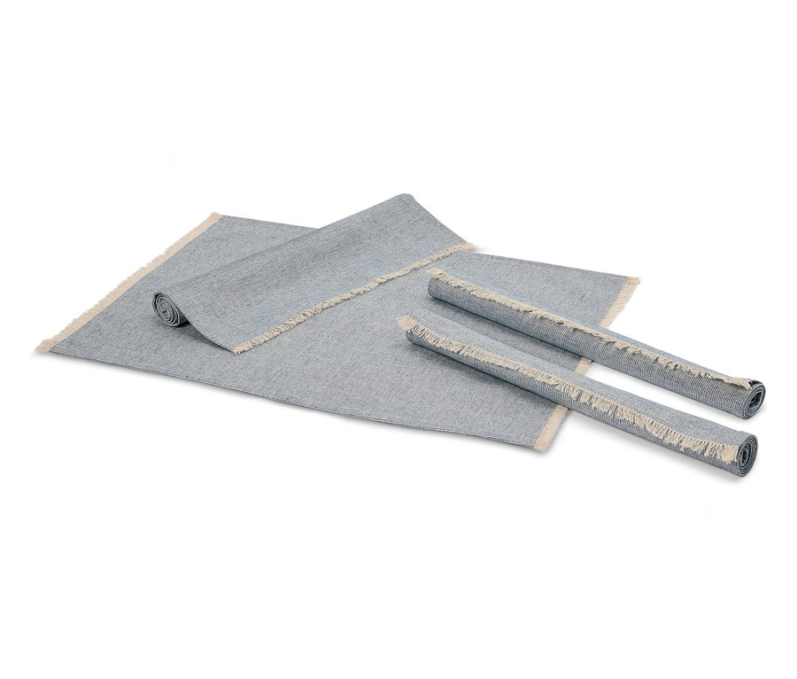 Zwei zusammengerollte graue Teppiche und ein ausgerollter grauer Teppich mit Fransen.