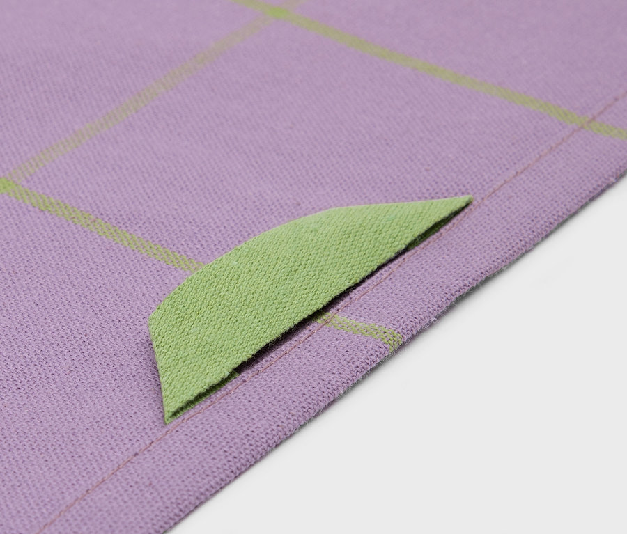 Detailaufnahme eines lila Stoffes mit limettengrünem Rand und Gittermuster.