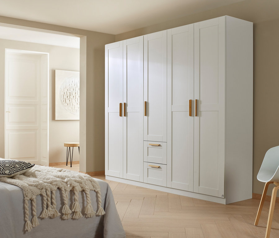 Schlafzimmer mit weißem Bett und großem, weißen rauch Drehtürenschrank »Quadra-Spin Country«, 5-türig.